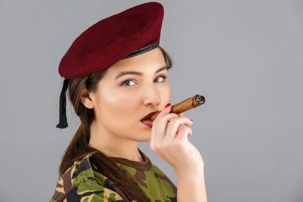 Gyönyörű fiatal nő, egy szivart, a katona ruha — Stock Fotó