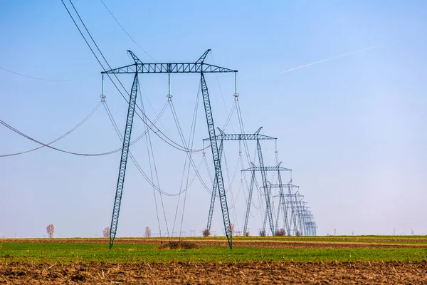 Pilones de electricidad en un campo agrícola — Foto de Stock