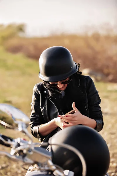Beautiful motorcycle brunette woman with a classic motorcycle (c