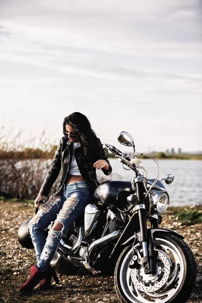 Όμορφη μοτοσυκλέτα μελαχρινή γυναίκα με μια μοτοσικλέτα κλασικό (c — Φωτογραφία Αρχείου