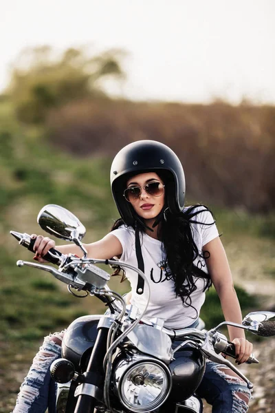 Mooie motorfiets brunette vrouw met een klassieke motorfiets (c — Stockfoto