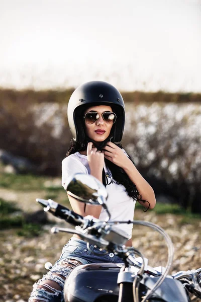 Beautiful motorcycle brunette woman with a classic motorcycle (c