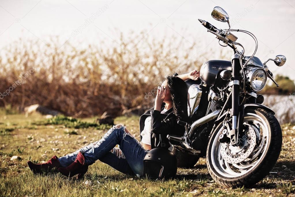 Beautiful motorcycle brunette woman with a classic motorcycle (c