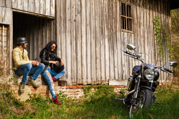 Hermosa pareja joven con una motocicleta clásica — Foto de Stock