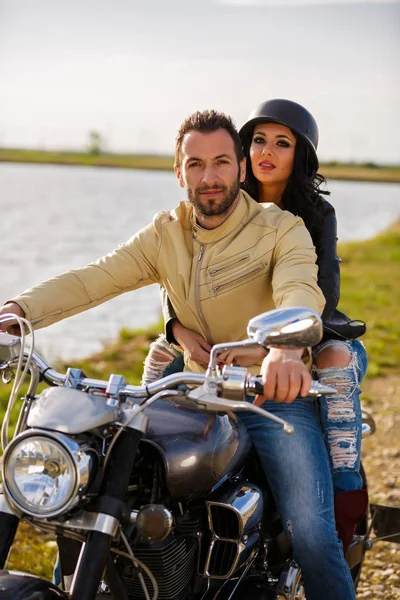 Gyönyörű fiatal pár egy klasszikus motorkerékpár — Stock Fotó