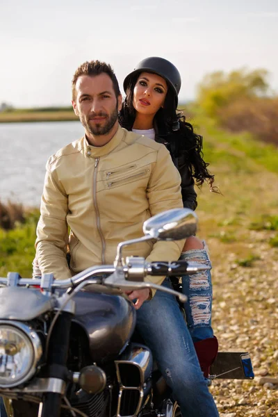 Belo jovem casal com uma motocicleta clássica — Fotografia de Stock