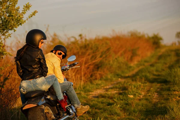 Belo jovem casal com uma motocicleta clássica — Fotografia de Stock