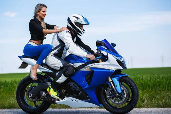 Beau jeune couple avec une moto de vitesse — Photo