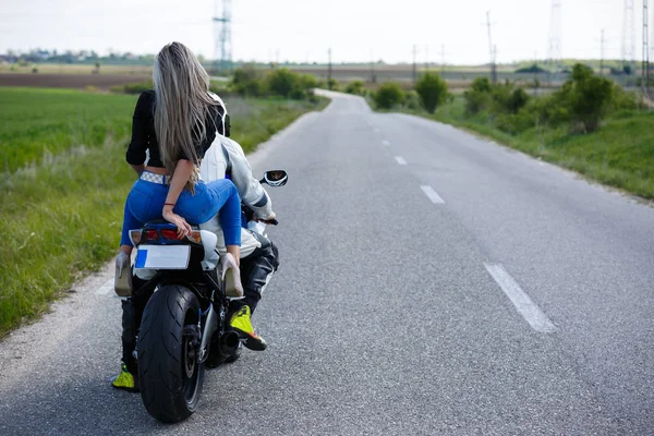 Belo jovem casal com uma moto velocidade — Fotografia de Stock