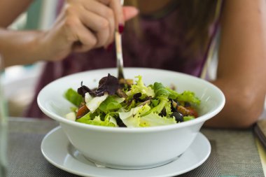 Beyaz bir kase içinde çeşit çeşit sebze salatası