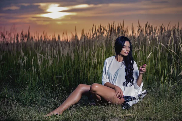 Mujer en la hierba al atardecer —  Fotos de Stock