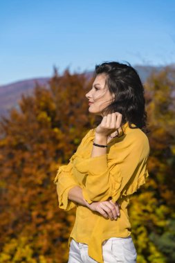 Genç esmer güzel güneşli bir sonbahar doğada sahiptir