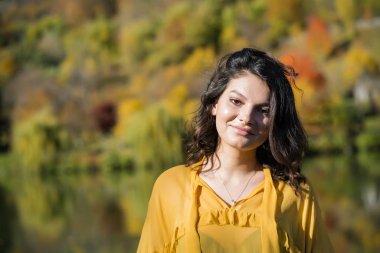 Genç esmer güzel güneşli bir sonbahar doğada sahiptir