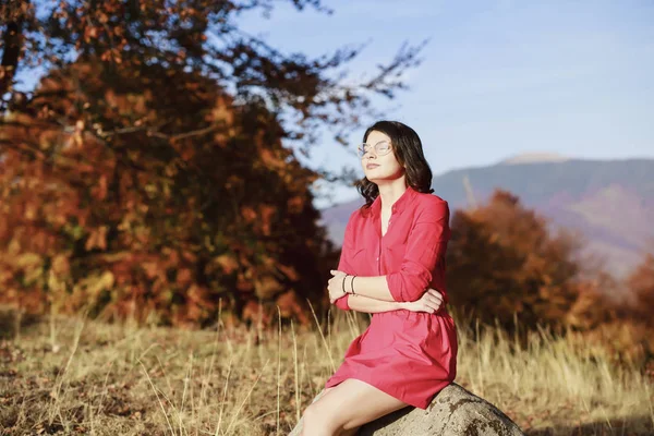 Beautiful young brunette enjoys a sunny day of autumn in nature — Stock Photo, Image
