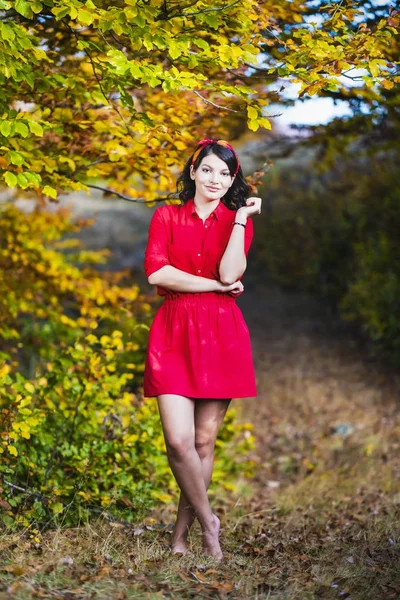 Beautiful young brunette enjoys a sunny day of autumn in nature — Stock Photo, Image