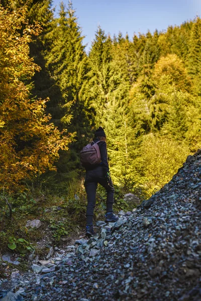 在树林小径上背着背包的女人徒步旅行 — 图库照片