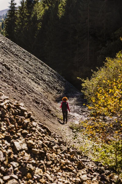 Természetjáró hölgy egy ösvényen az átkelést hátizsák — Stock Fotó