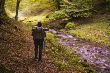 Uzun yürüyüşe çıkan kimse dağın ormanın içinde bir iz sırt ile