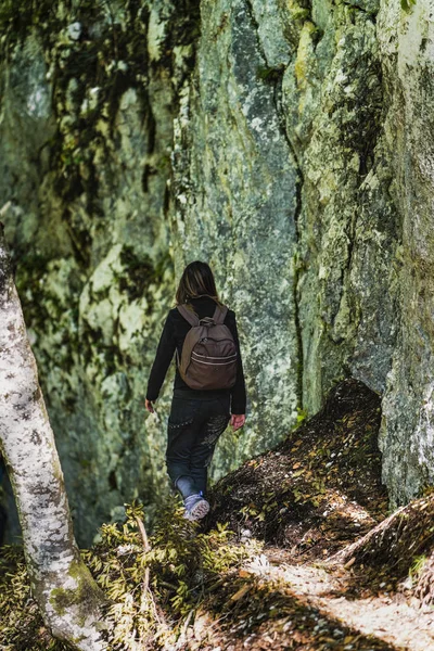 Nő túrázó a hátizsák egy ösvényen az erdő — Stock Fotó