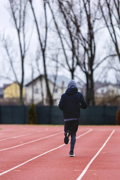 运动员亚洲青年男子在体育场跑道上奔跑。健康 — 图库照片