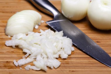 Soğan ve soğan dilimleri ahşap kesme tahtası üzerinde.