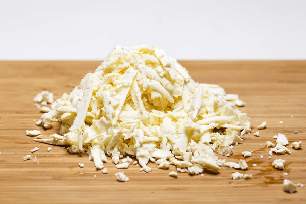 Reszelt mozzarella sajt, egy vágódeszka és egy konyhai reszelő — Stock Fotó