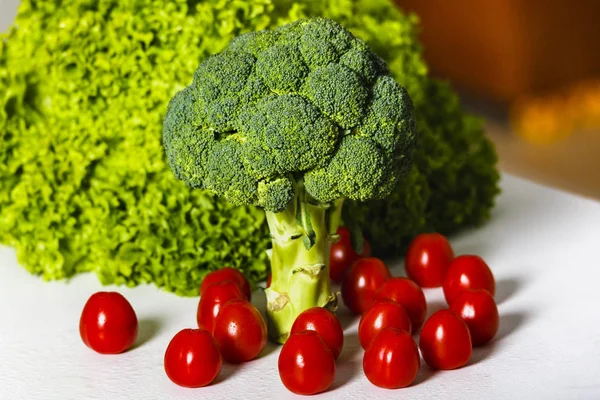 Brokolice, zelené salátu a cherry rajčátky na stůl — Stock fotografie