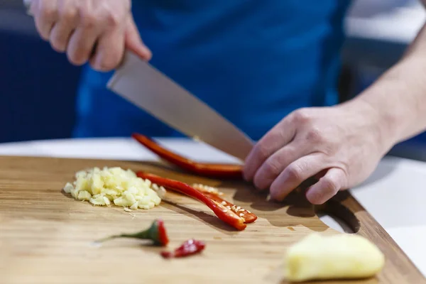 Homme coupe des légumes sur un bois dans la cuisine — Photo