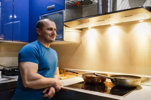 Muž v kuchyni vaří doma na wok — Stock fotografie