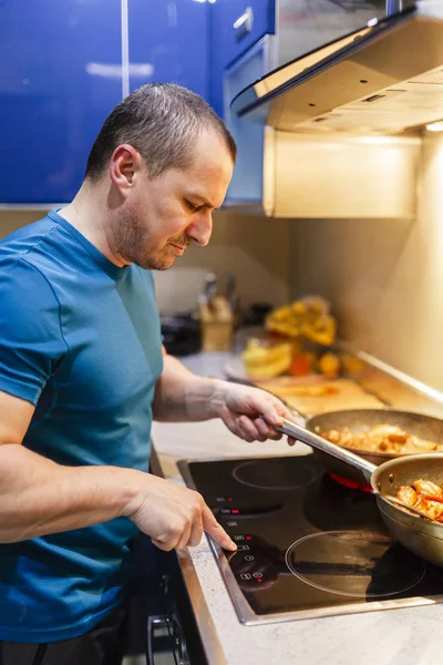 Az ember a konyhában a főzés otthon a wok — Stock Fotó