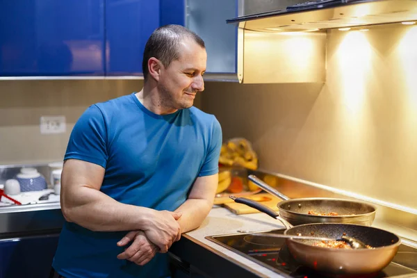 Muž v kuchyni vaří doma na wok — Stock fotografie