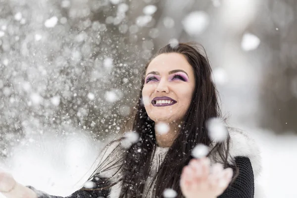 女の子は公園で雪と遊ぶ — ストック写真