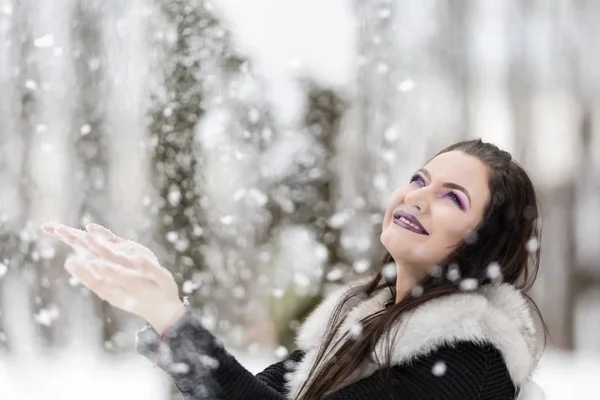 女の子は公園で雪と遊ぶ — ストック写真