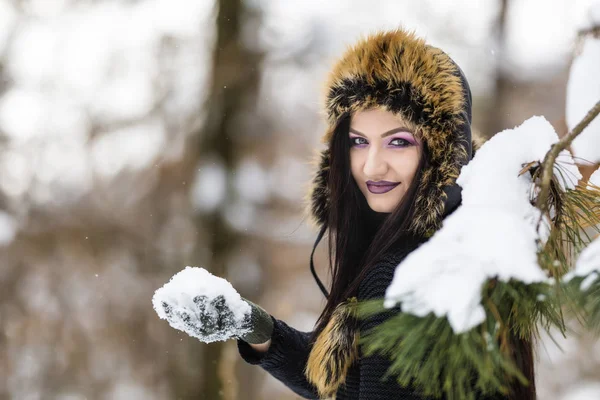 女の子は公園で雪と遊ぶ — ストック写真