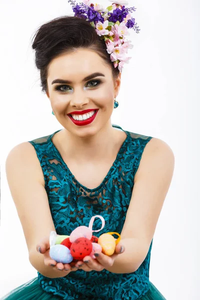 Una hermosa chica con un vestido verde sostiene un huevo de Pascua en su ha — Foto de Stock