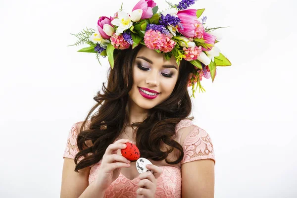 Gyönyörű fiatal hölgy, üti két színes tojások, húsvéti dekoráció. — Stock Fotó