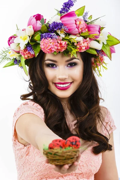 The beautiful brunette woman offers colorful easter eggs — Stock Photo, Image