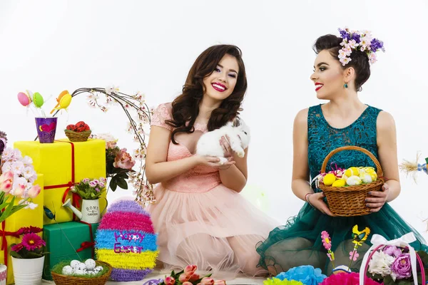 Twee mooie vrouwen spelen in Pasen decoratie met een konijn. — Stockfoto