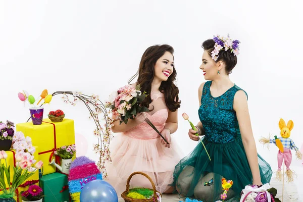 Twee mooie vriendin meisjes, mand met eieren en bloem deco — Stockfoto
