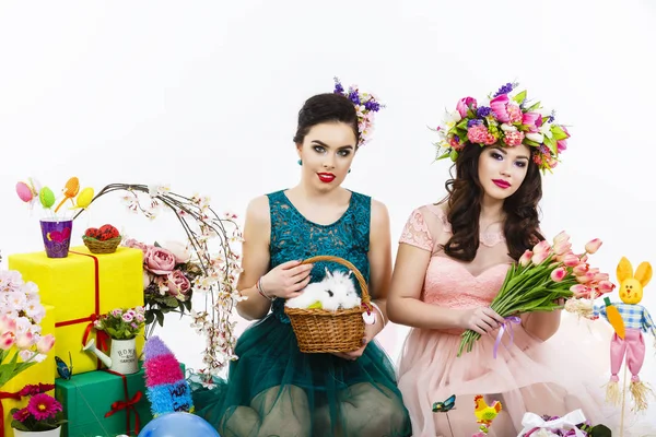 Twee mooie vrouwen spelen in Pasen decoratie met een konijn. — Stockfoto