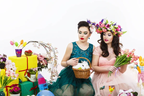 Two beautiful women playing in easter decoration with a rabbit. — Stock Photo, Image