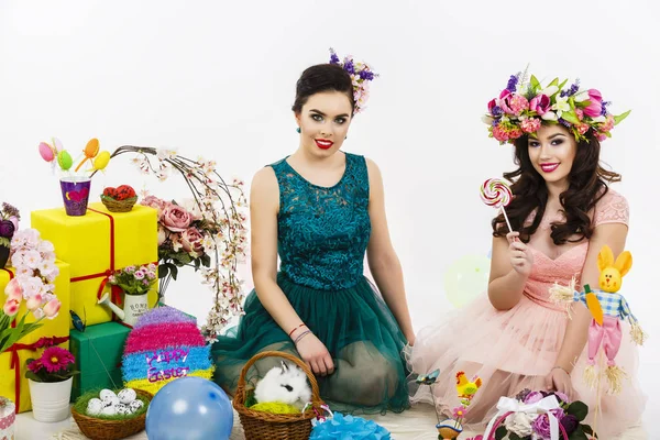 Dos hermosas mujeres jugando en la decoración de Pascua con un conejo . — Foto de Stock