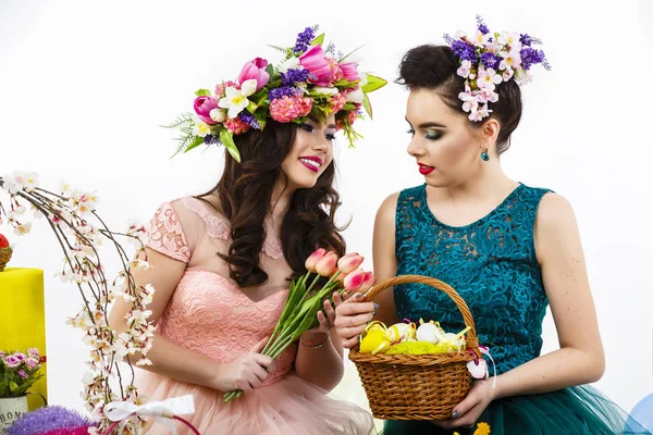 Dos hermosas chicas amigas, cesta con huevos y flor deco — Foto de Stock