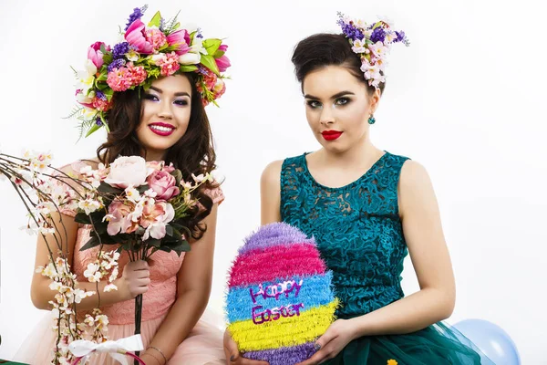 Twee mooie vriendin meisjes, mand met eieren en bloem deco — Stockfoto