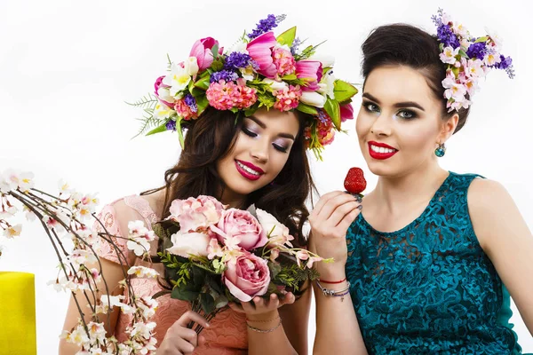 Two beautiful girl friends with strawberries and decoration flow — Stock Photo, Image