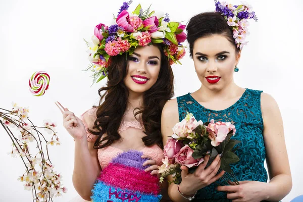 两个漂亮的女孩朋友用糖果和花装饰。猪圈 — 图库照片