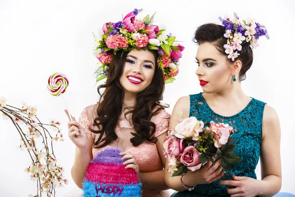 Duas amigas bonitas com doces e decoração de flores. pocilga — Fotografia de Stock