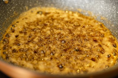 Kahverengi şeker bir wok tavada caramelizing