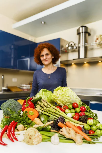 Evde yemek, sebze büyük bir yığın üzerinde bo sahip kadın — Stok fotoğraf