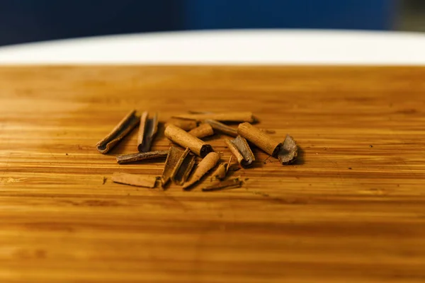 Broken cinnamon sticks on a wooden board — Stock Photo, Image